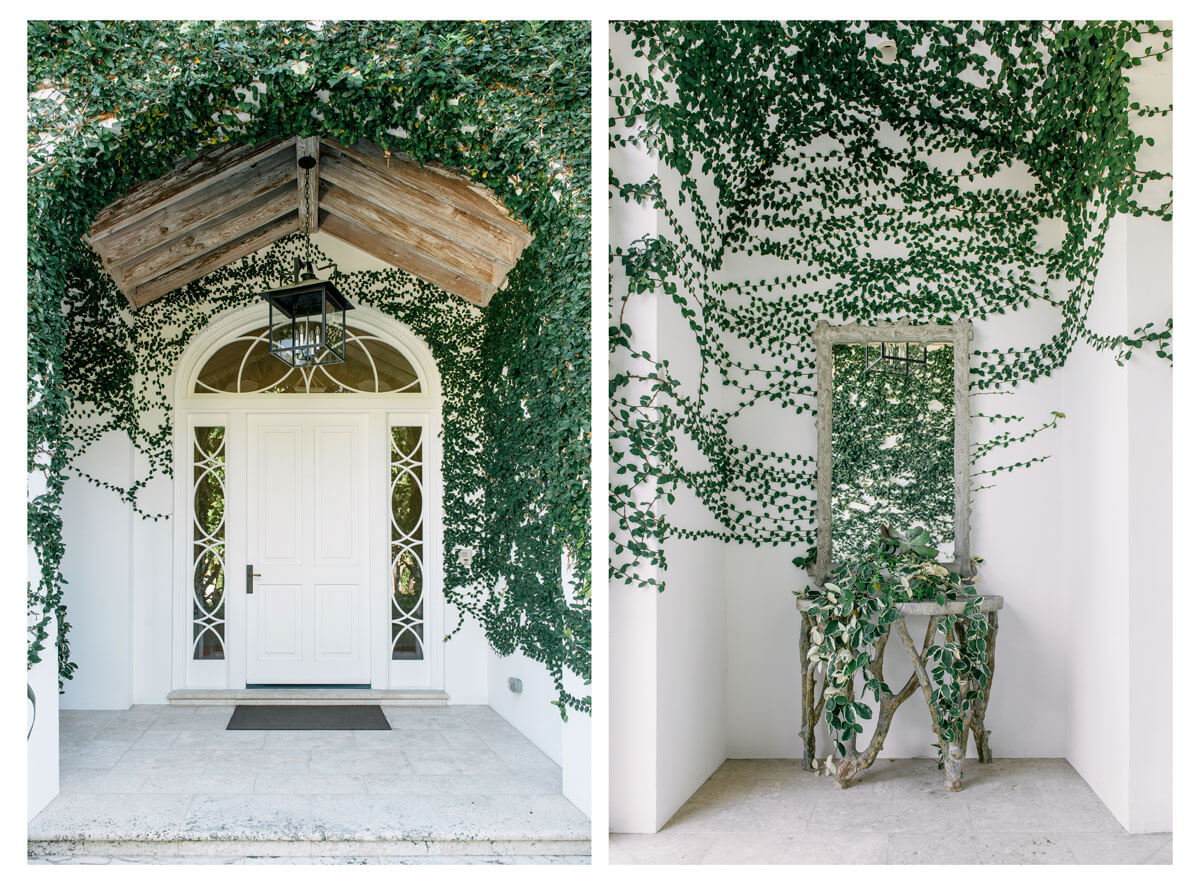 A large white door with vines surrounding, and a wooden table with mirror attached surrounded by vines | Corcoran