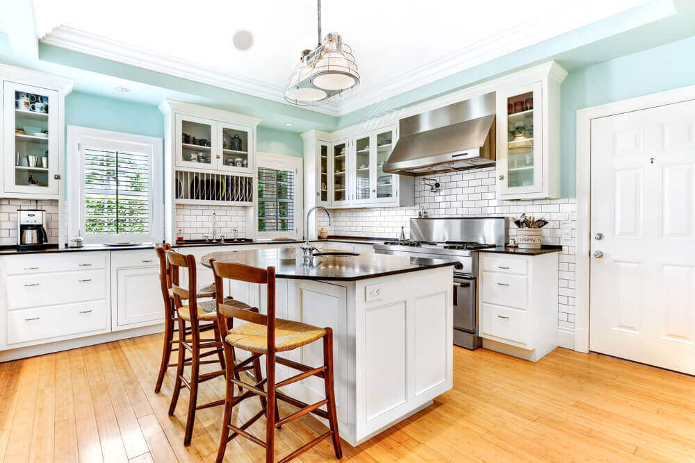 A kitchen with white cabinets and light blue walls | Corcoran