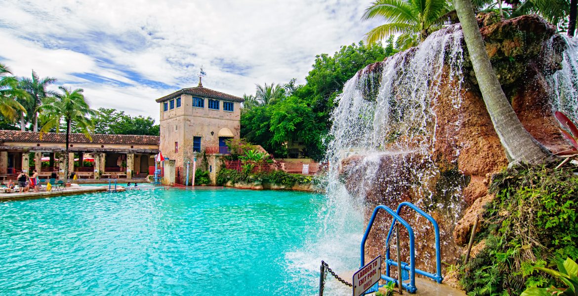 The Venetian Pool at Coral Gables features weathered buildings, gondola poles, and waterfalls.