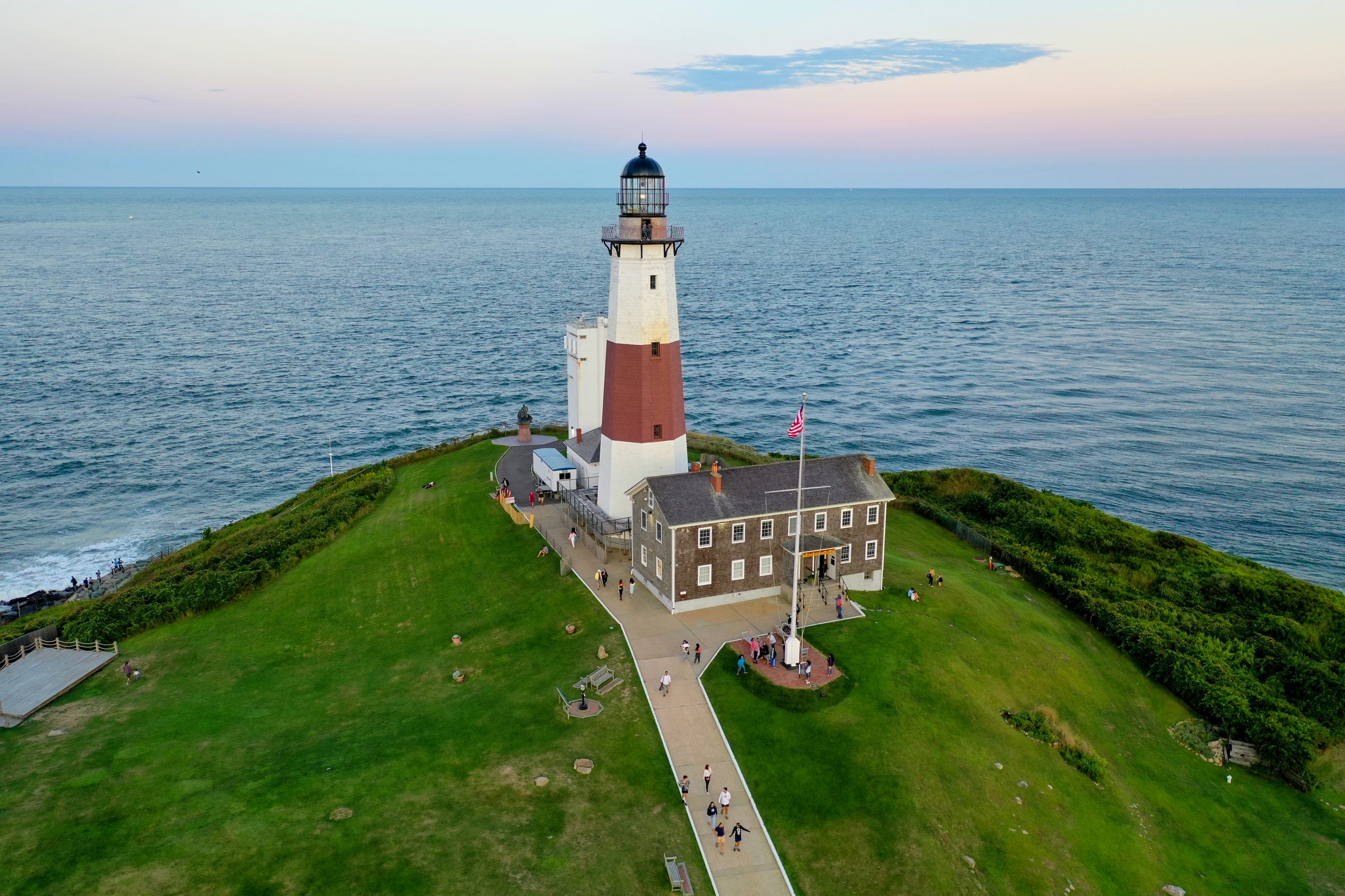 The Montauk Point Lighthouse high above its hill in Montauk with the Atlantic Ocean in the background.