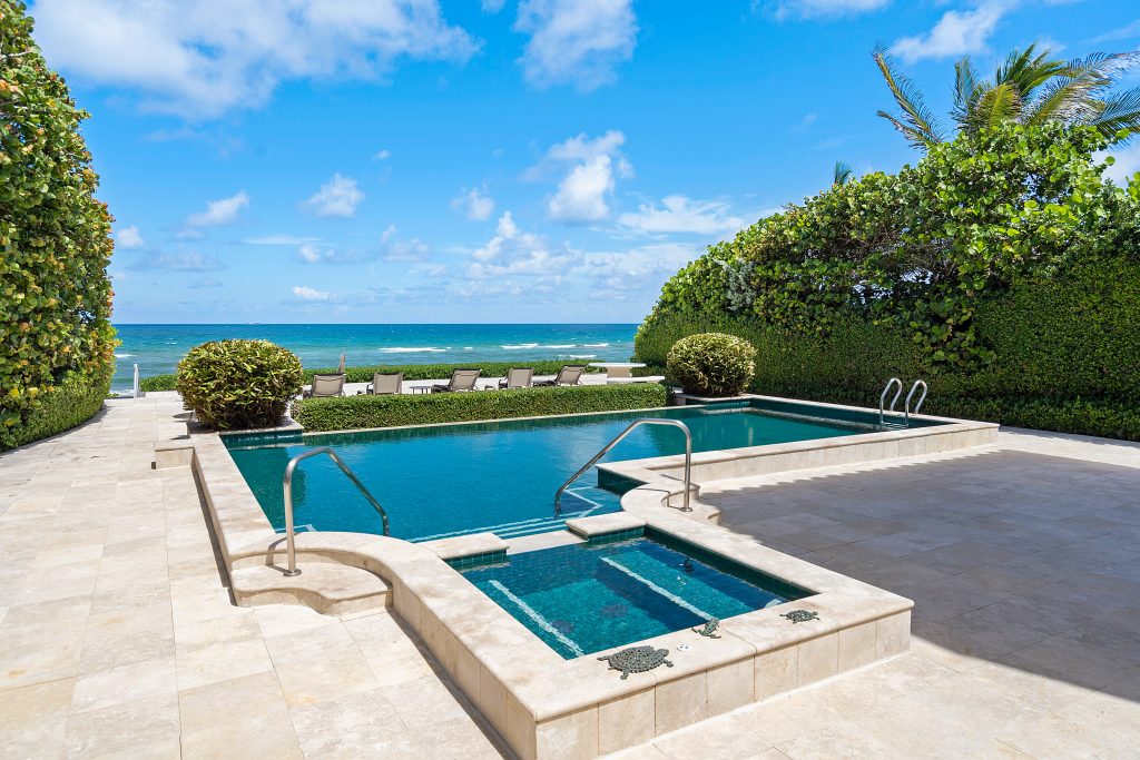 Oceanfront views, lush green landscaping, and an infinity pool help define the stellar backyard at 3603 North Ocean Boulevard.