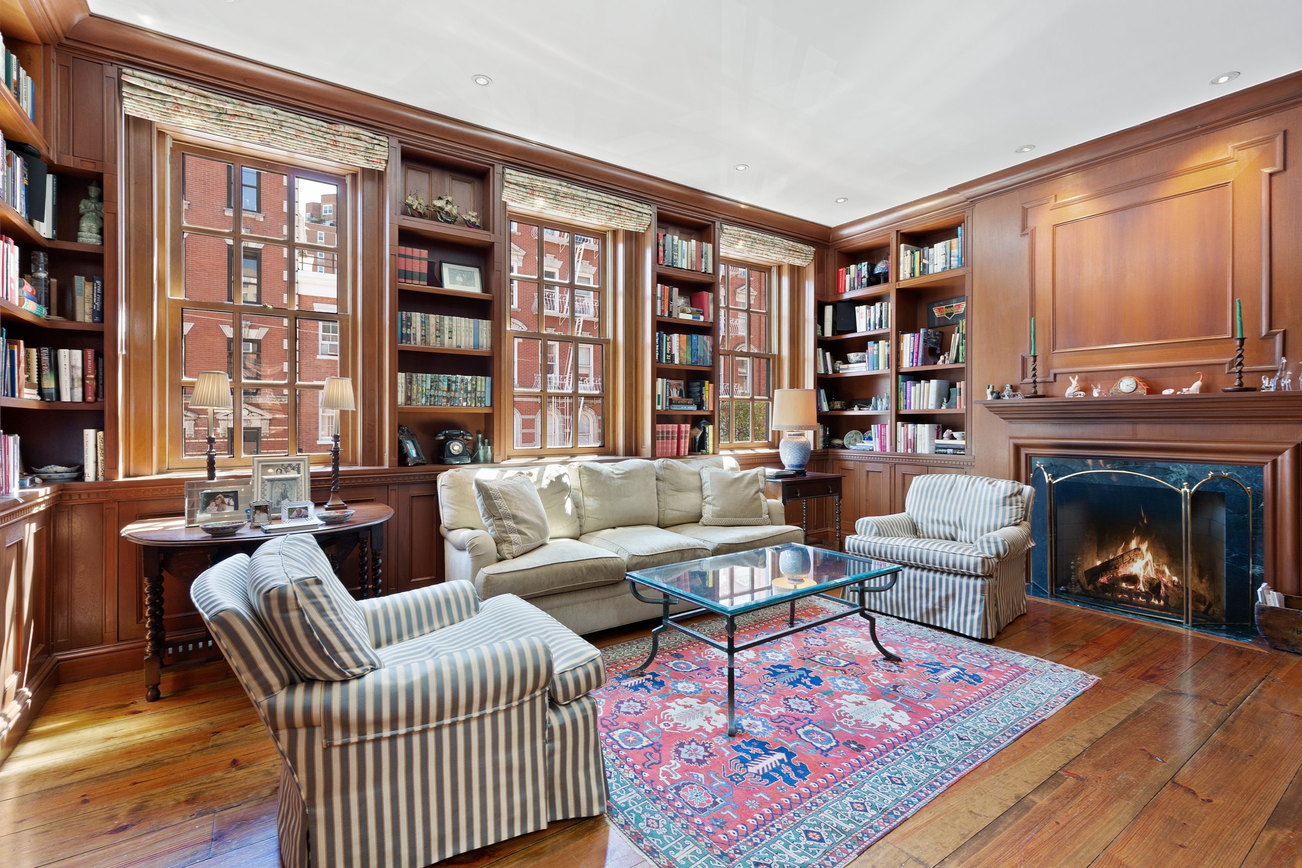 The mahogany walled library at 19 King Street in SoHo has a fireplace and built-in walls of bookshelves.