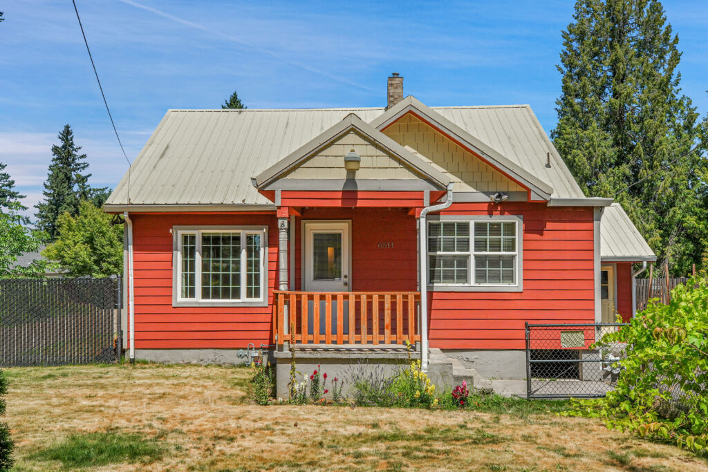 A red house with a beige roof and white trim.