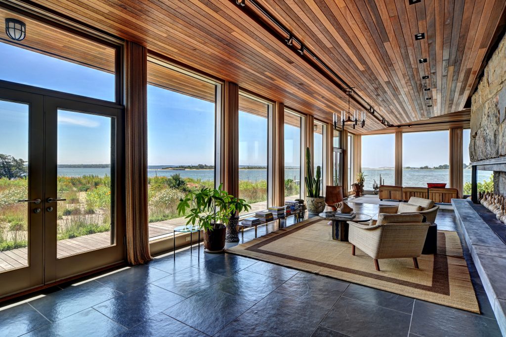 The wild East End landscape and scenic bay are visible from the living room at 2 Charlies Lane, which sits on stone floors and under mahogany ceilings.
