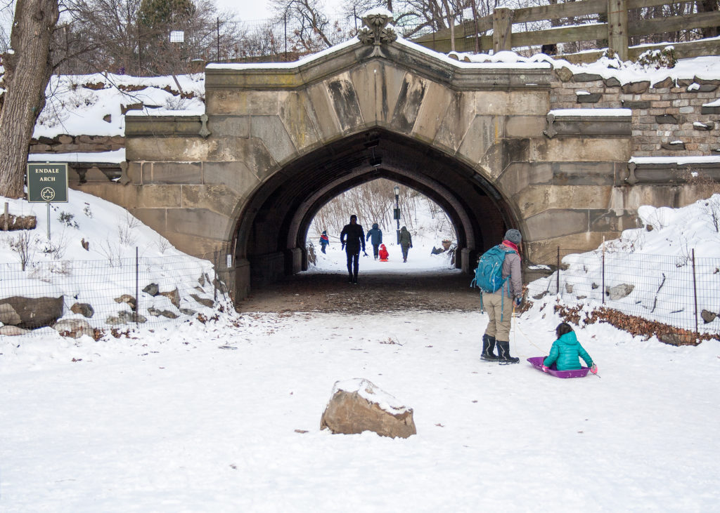 A child is taken sledding by the historic Endale Arch in Prospect Park.