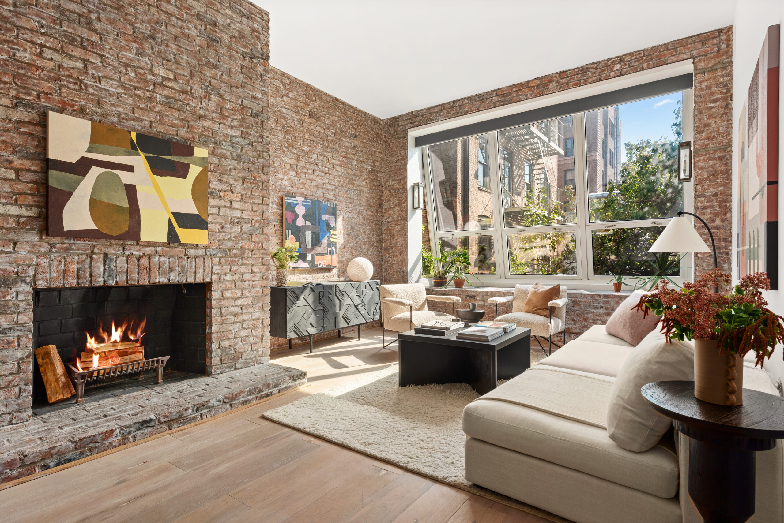 A wood-burning fireplace sits inside a brick surround that spans from floor to ceiling.