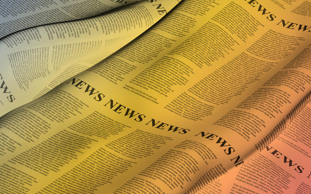 A close-up image of wavy sheets of newspaper with the word NEWS repeatedly printed in large letters at the top, overlaid with a gradient of warm yellow and orange lighting.