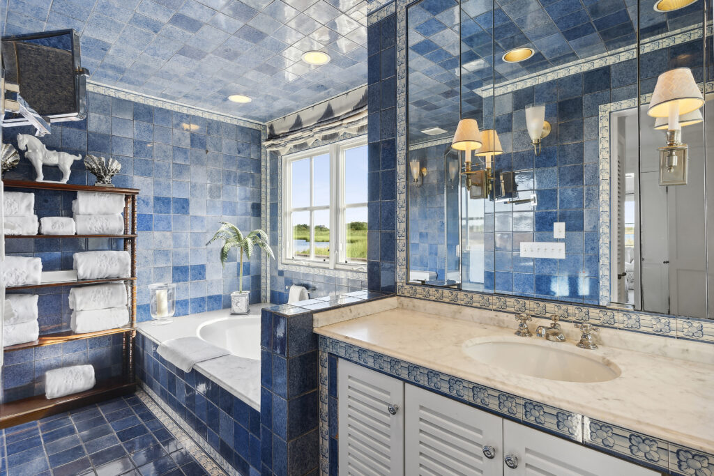 Several shades of blue tile surround the bathtub of this bayside Southampton home.