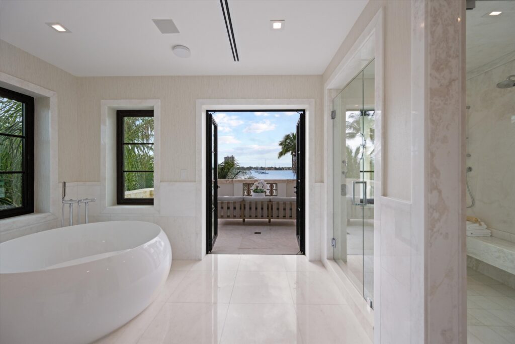 The bathtub at this Palm Beach home sits behind French doors from a terrace overlooking the water.