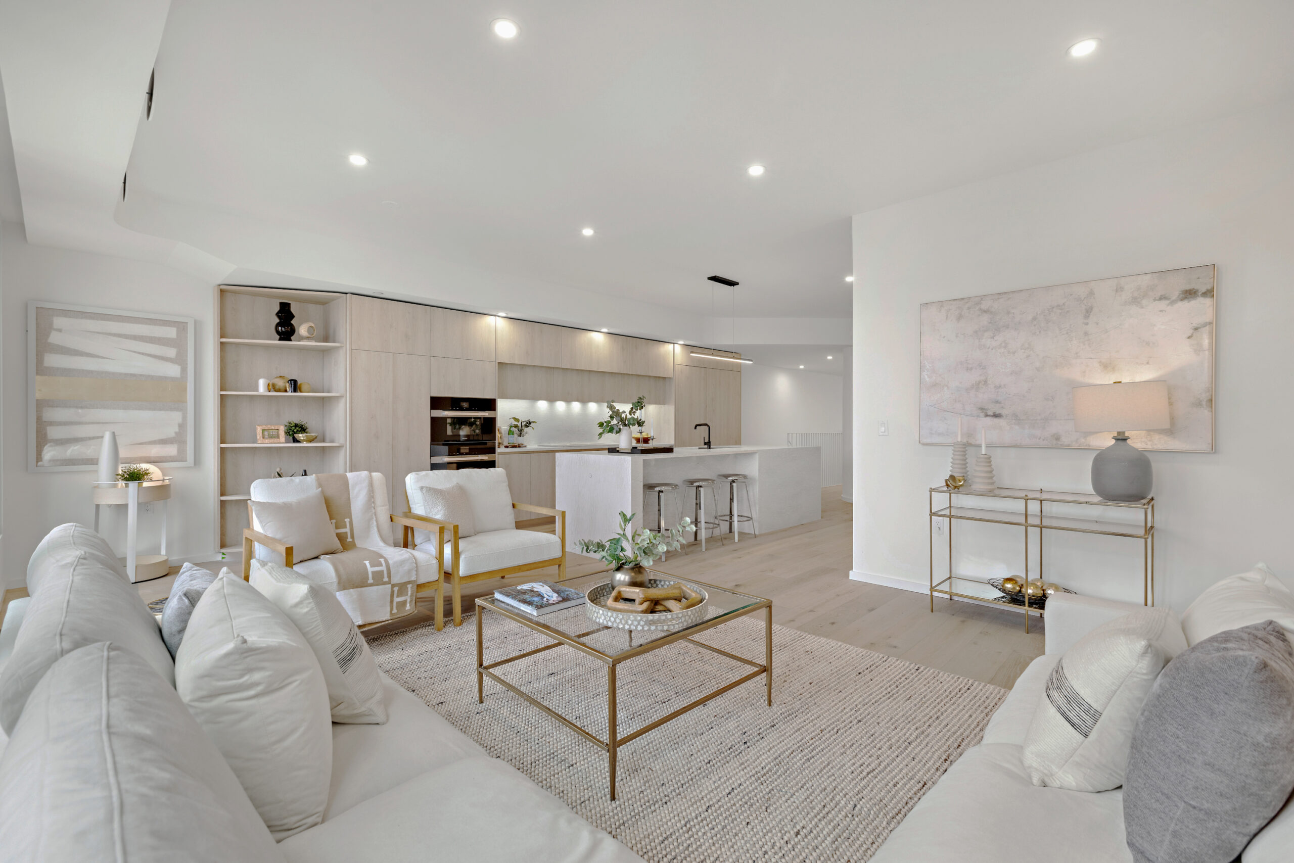 inside of an all-white living room with white sofas and a glass coffee table