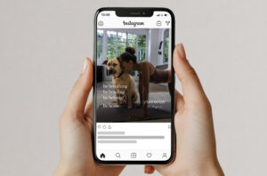 A person doing yoga in plank pose indoors next to a dog, with sunlight streaming through windows. Text on the image reads: be breathing, be bending, be beloved, be home. corcoran.