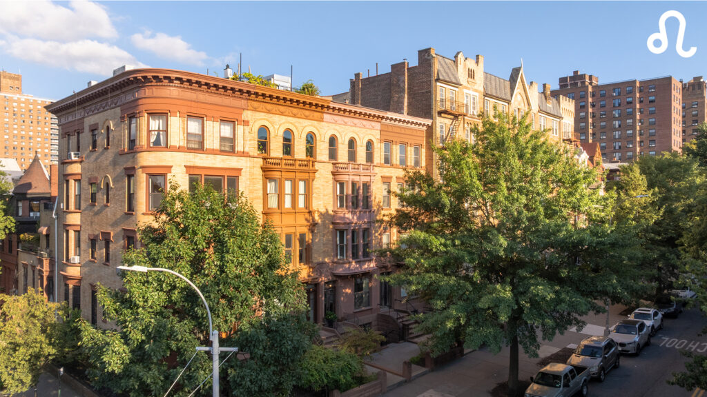 A row of historic brownstone buildings with ornate architecture stands along a tree-lined street under a sunny sky; during Scorpio season, leafy green trees and parked cars line the curb, casting intriguing shadows like astrological houses.